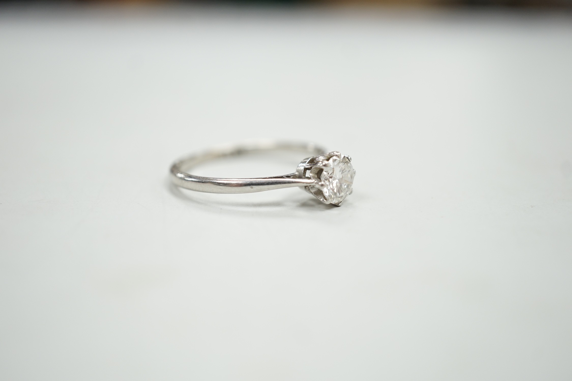 A white metal (stamped plat) and solitaire diamond ring, size P, gross weight 2.9 grams